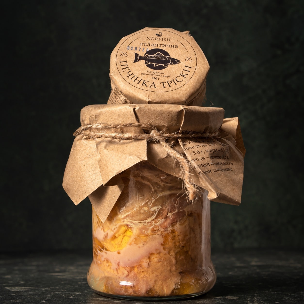 Скляна банка печінки тріски NORFISH Atlantic 250 г на темно-графітовому фоні